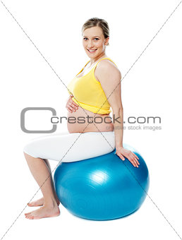 Relaxed pregnant woman sitting on pilate ball