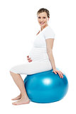 Pregnant lady sitting on exercise ball