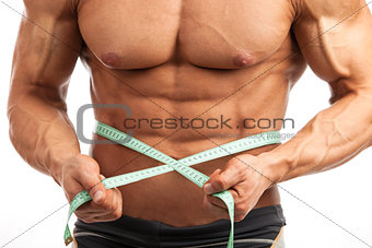 Closeup of muscular man with measuring tape