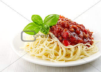 Spaghetti bolognese and green basil leaf