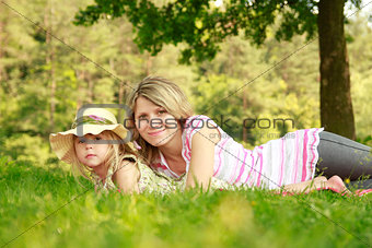 Mama and her little daughter playing on grass