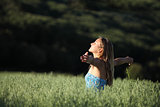 Attractive woman breathing joyful in a green meadow