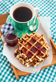 Breakfast with belgian waffles with jam and coffee