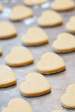 Unbaked heart shaped shortbread cookies on baking tray, selectiv