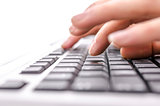 Detail of female fingers typing on keyboard