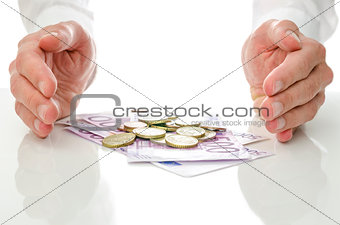 Hands around Euro coins and banknotes