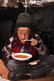 Poor beggar child eating charity food