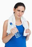 Brunette wearing sportswear with a towel and a bottle