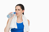 Sportswoman with a towel drinking water