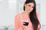 Sad woman holding glass of wine