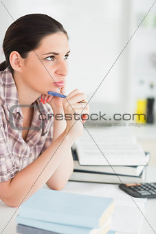 Woman thinking while holding a pen