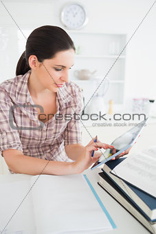Woman holding a tablet computer while touching it