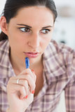 Close up of a woman thinking while holding a pen