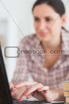Woman typing on keyboard of laptop
