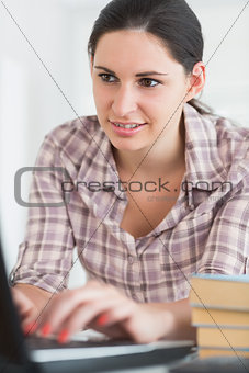Woman typing on a keyboard while looking at a screen