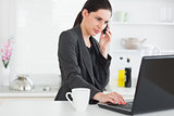 Woman calling while using a laptop