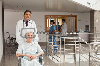 Doctor pushing woman in a wheelchair