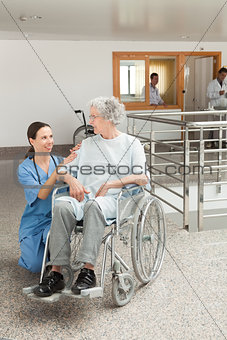 Nurse looking after old women sitting in wheelchair