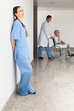 Nurse leaning against wall