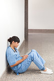 Nurse sitting on the ground looking at file