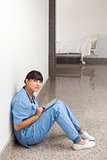 Nurse sitting on the ground with tablet computer
