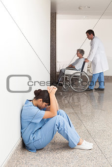 Nurse sitting in the hallway getting depressed