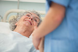 Elderly patient looking up at nurse