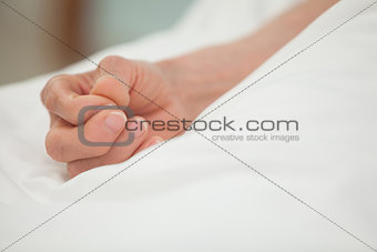 Hand in white bed cover