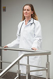 Female doctor proudly standing on the top of the stairs
