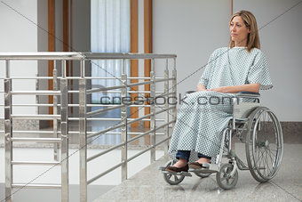 Woman sitting in wheelchair in hospital corridor