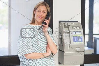 Smiling patient using payphone