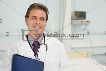 Smiling doctor holding a folder in bedroom