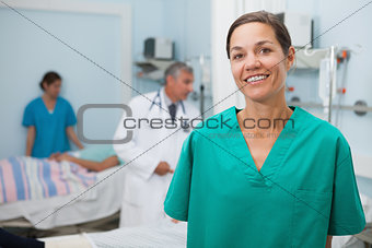 Nurse standing hospital room and smiling