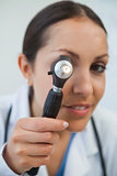 Doctor looking through otoscope