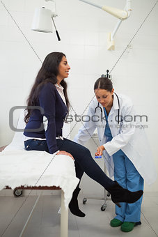 Doctor looking at the leg of the woman