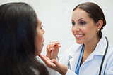 Womans mouth being examined by happy doctor