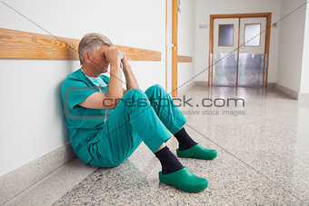 Doctor is sitting on the floor with hands in his face