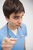 Male nurse is pointing at camera