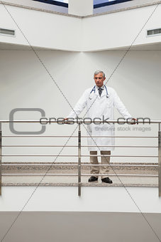 Doctor is standing at the railing of the corridor