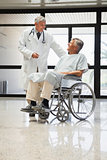 Doctor talking to a man in a wheelchair