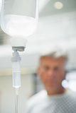 Intravenous drip with patient in background