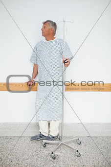 Man standing against the wall with his IV drip