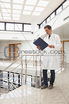 Doctor looking in his folder in hallway