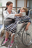 Female doctor adjusting child's neck brace in wheelchair