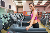 Smiling woman on a treadmill in the gym taking a break