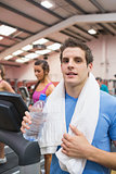 Man smiling and drinking water in gym