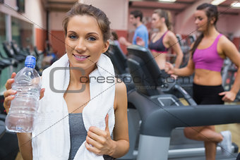 Woman drinking water in the gym