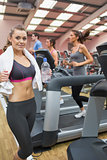 Woman in gym beside treadmill