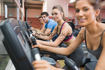 Four people working out on exercise bikes