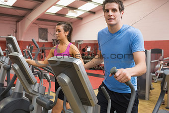 Woman and man training on a step machine